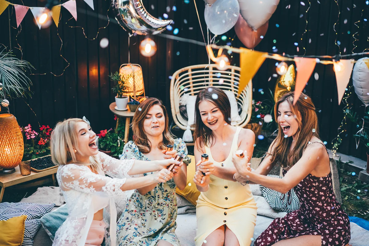 Cheerful girl friends hanging out at backyard party