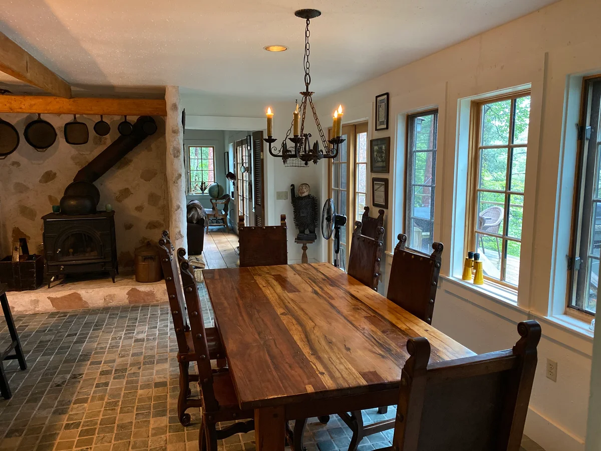 Country summer kitchen with wood burning stove, chandelier and large wooden dining table