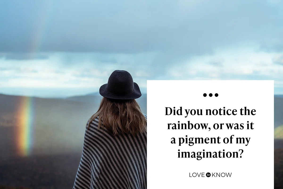 Young woman hiking through mountains and rainbow