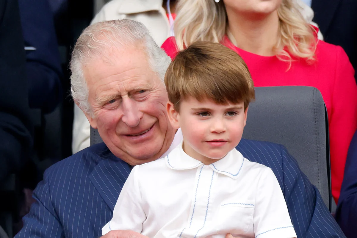 Prince Louis of Cambridge sits on his grandfather Prince Charles, Prince of Wales's