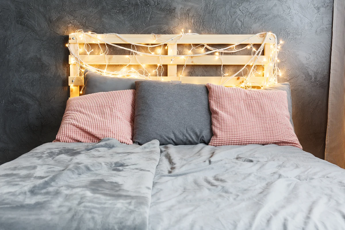 Cozy dreamy bed with decorated DIY pallet headboard