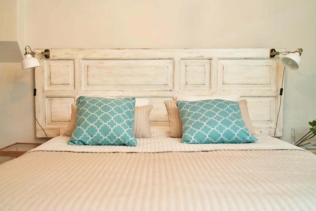 Wooden headboard with blue pillow in a stylish trendy decoration with copy space