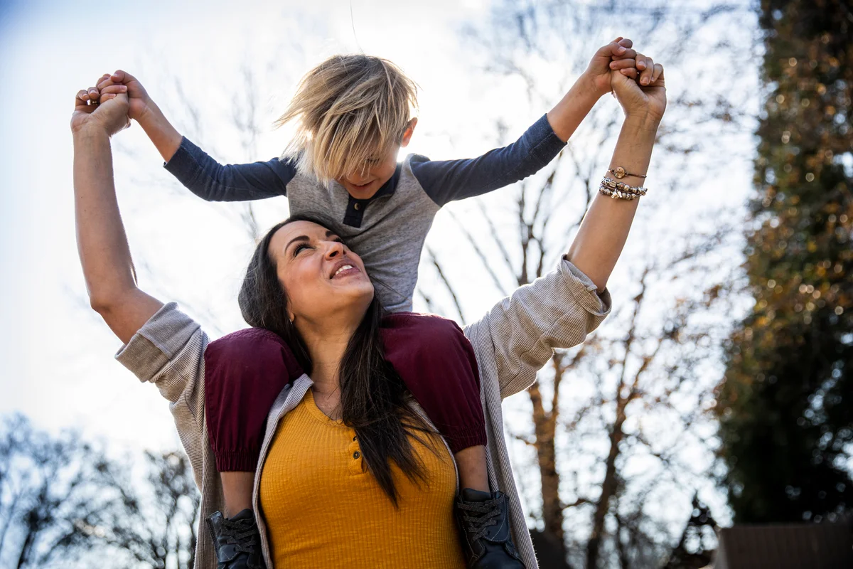 Son on mom's shoulder as they play