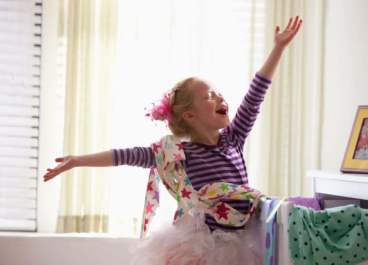 Little girl putting on stage performance at home