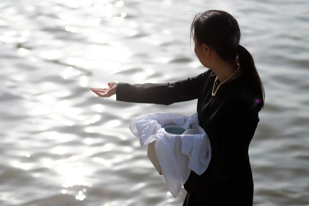 woman spreading ashes in water