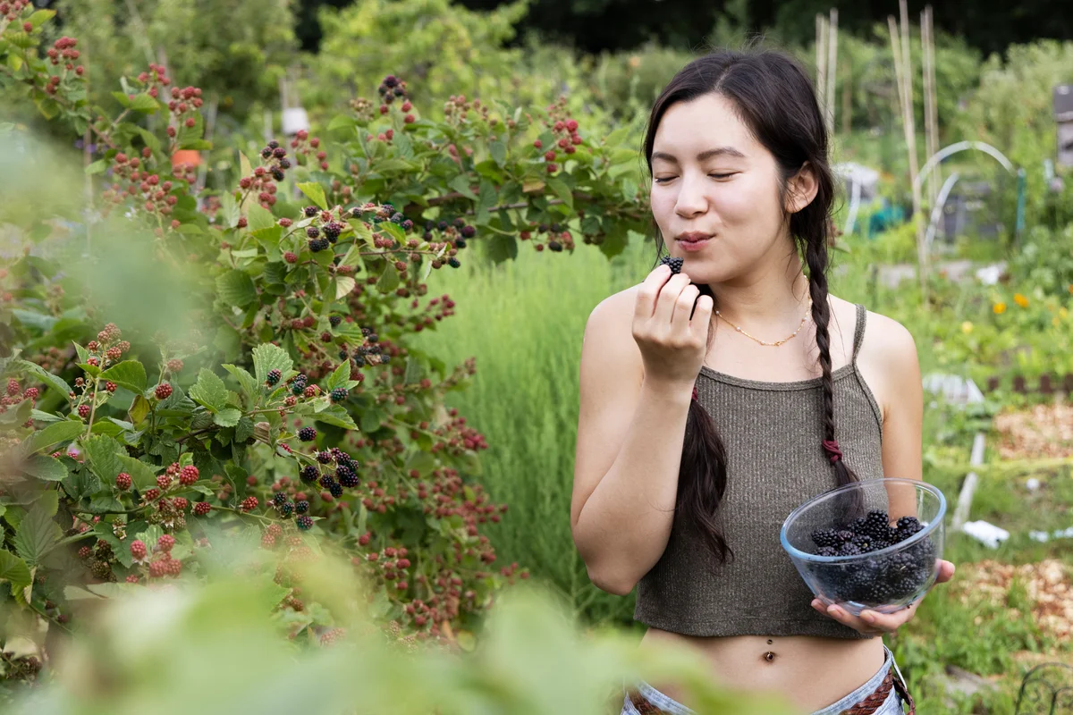 woman eating berries in the garden