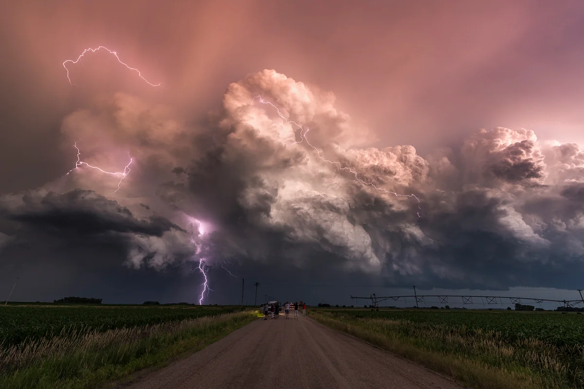 Electric storm at sunset watched by a group of storm chasers