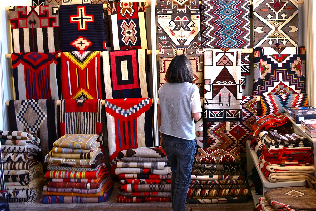A visitor admires Native American rugs made by weavers from the Navajo Nation - Getty Editorial