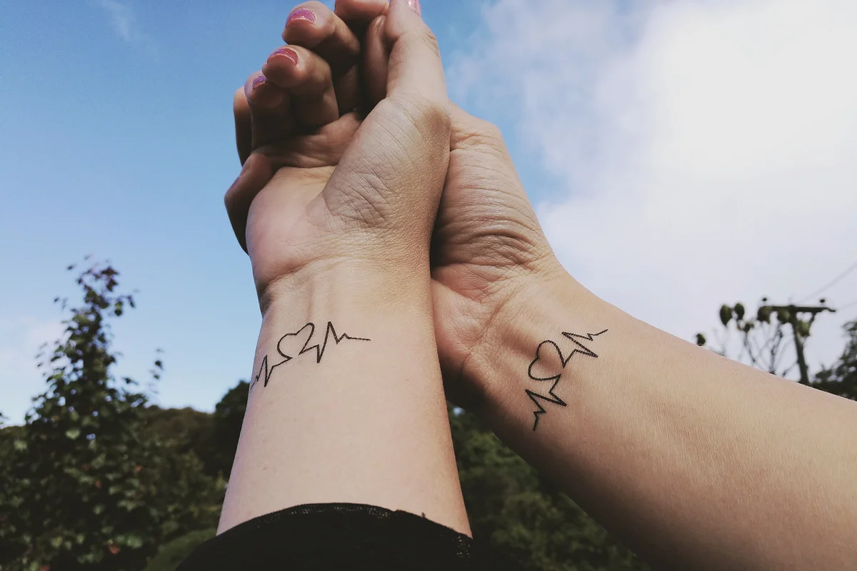 Cropped Hand Of Couple With Tattoo