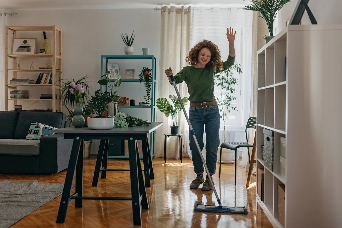 woman dancing and cleaning shiny wood floors