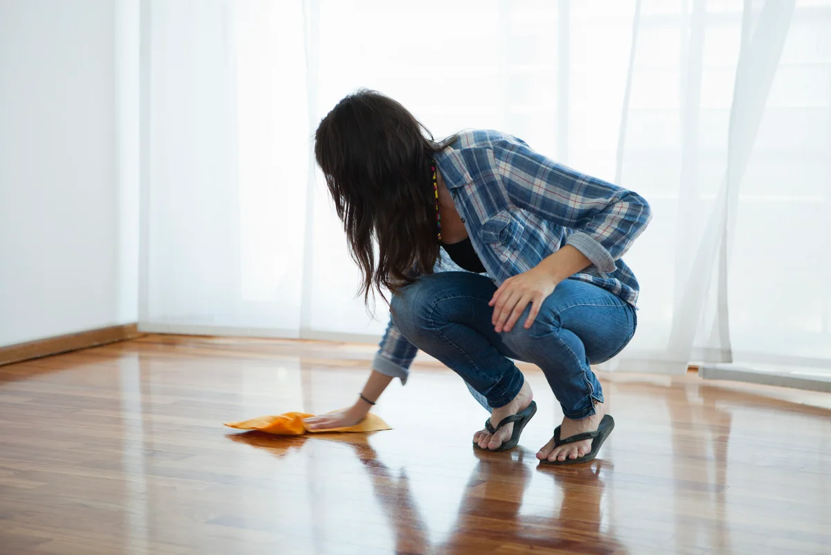 Woman wiping wood floors with microfiber cloth