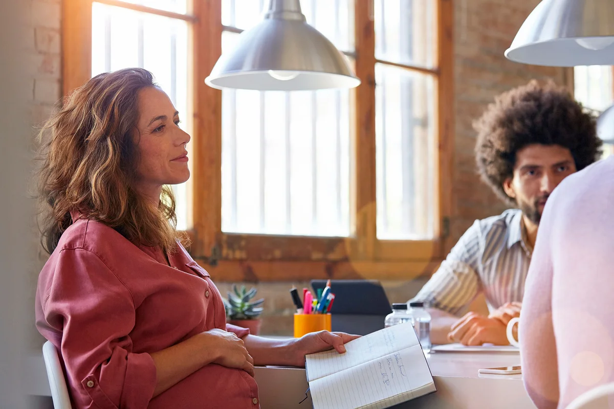 Pregnant businesswoman with colleagues in office