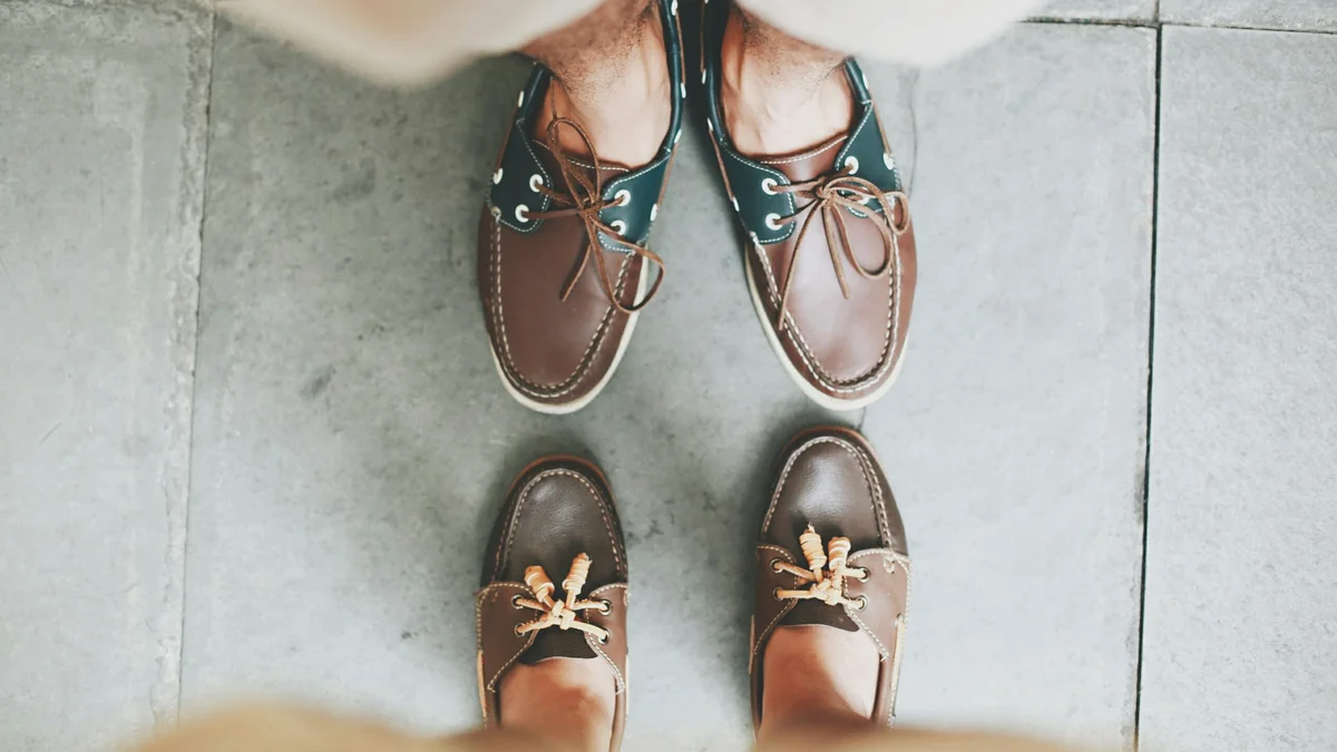 Shot of two people's Sperry boat shoes from above