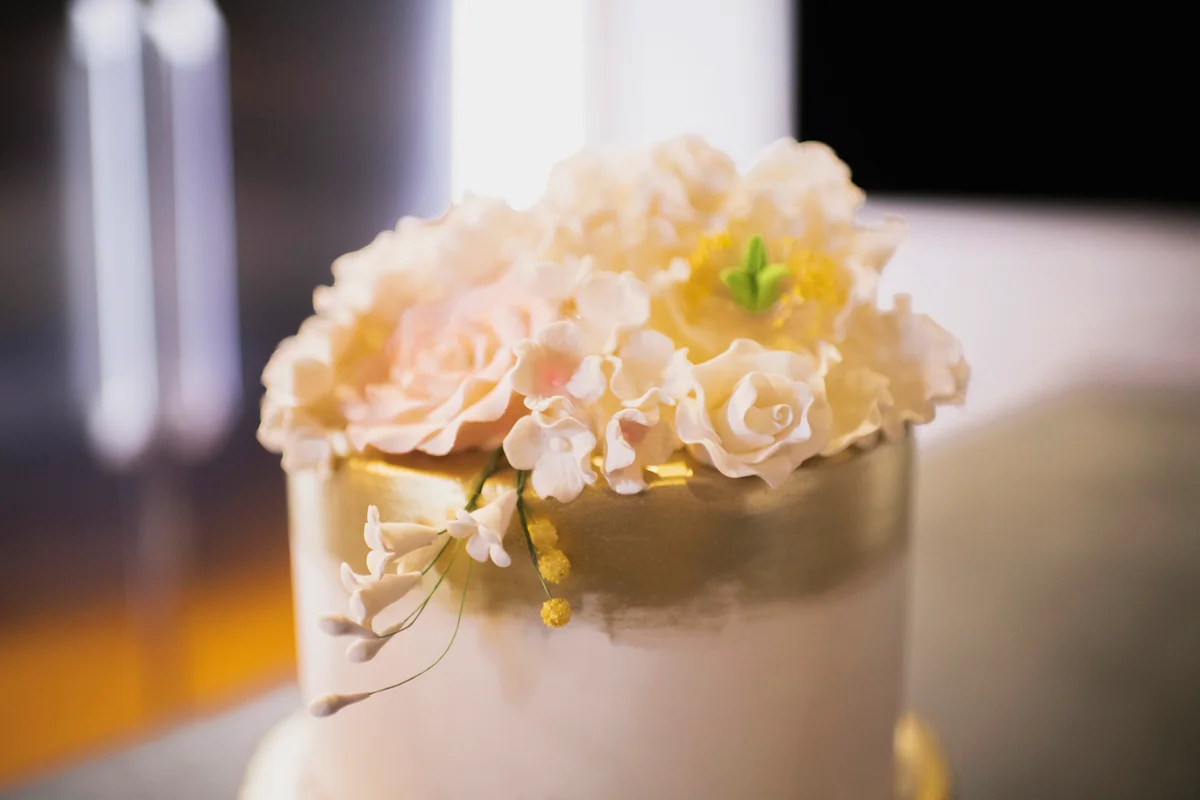 Elegant white and gold, two-tier anniversary cake on kitchen counter