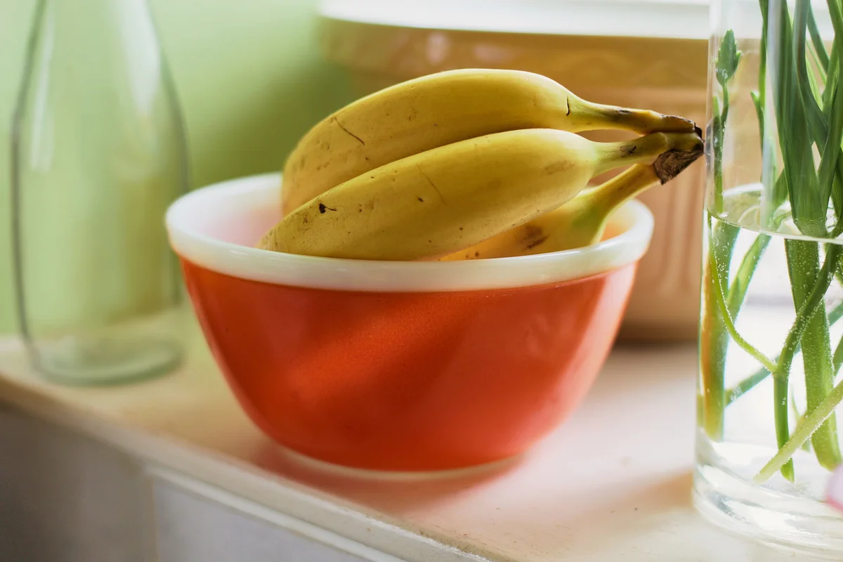 A bunch of bananas sitting in a pyrex bowl