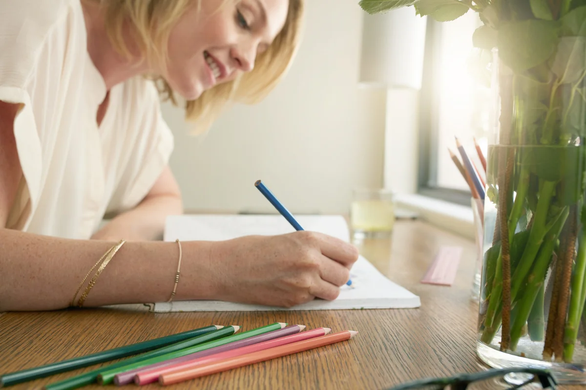 Woman coloring an adult coloring book with pencils