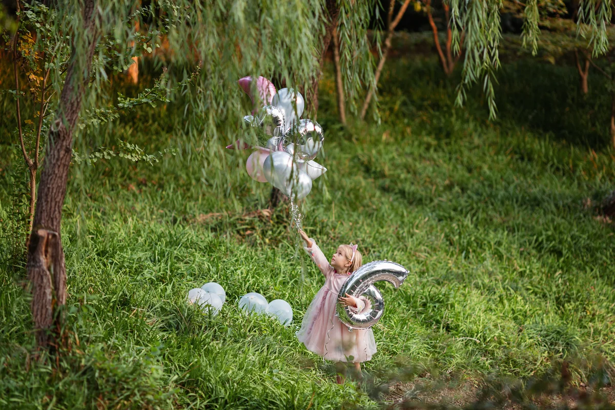 little girl with balloons in a park