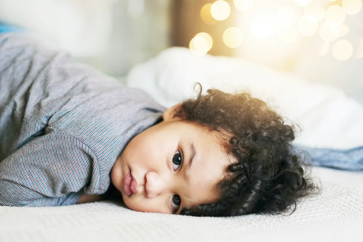 Baby boy lying down on the bed at home