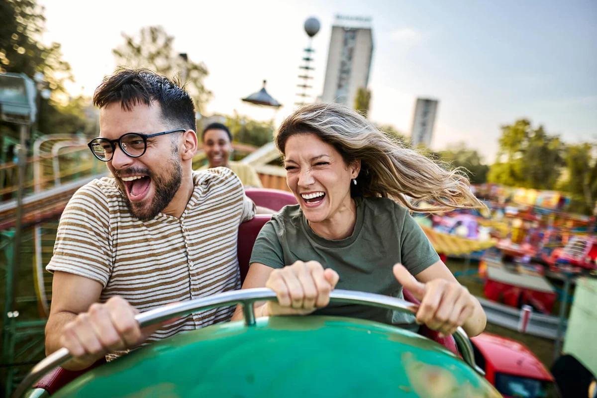 Young cheerful couple having fun on rollercoaster