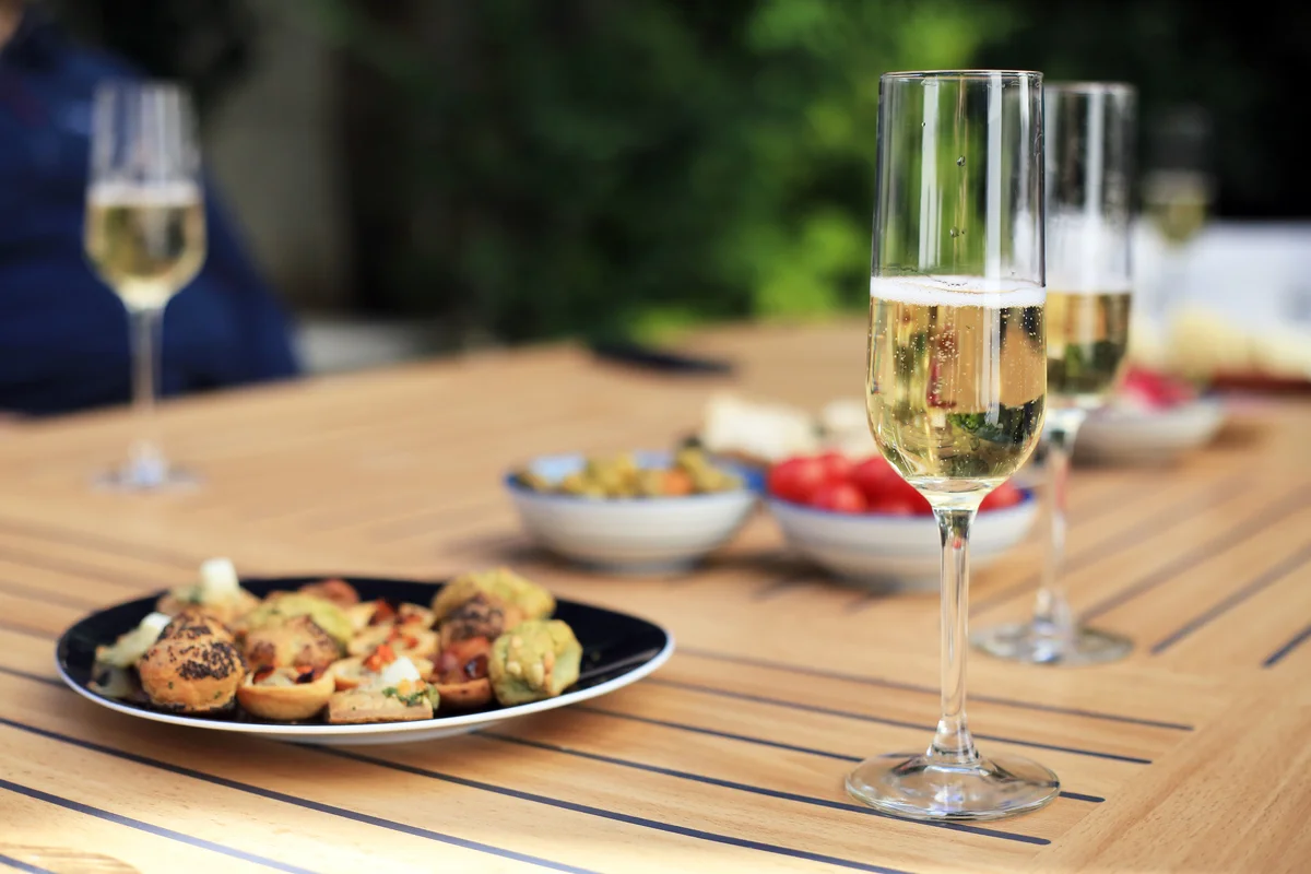 Champagne in glasses and table of appetizers