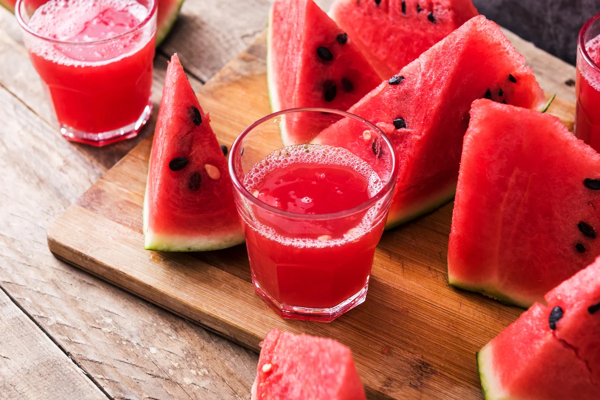 Small shot of cucumber drink surrounded by watermelons