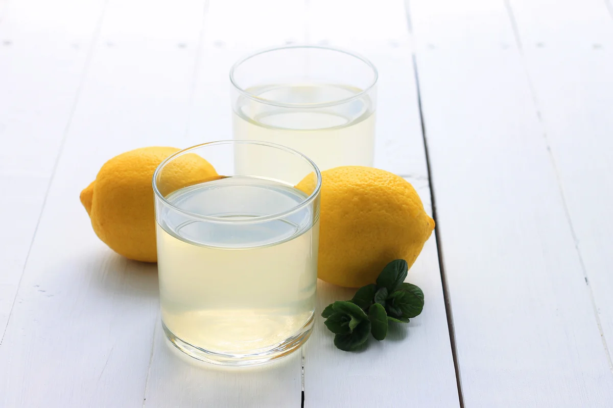 Cocktail glasses with lemon drink and lemons