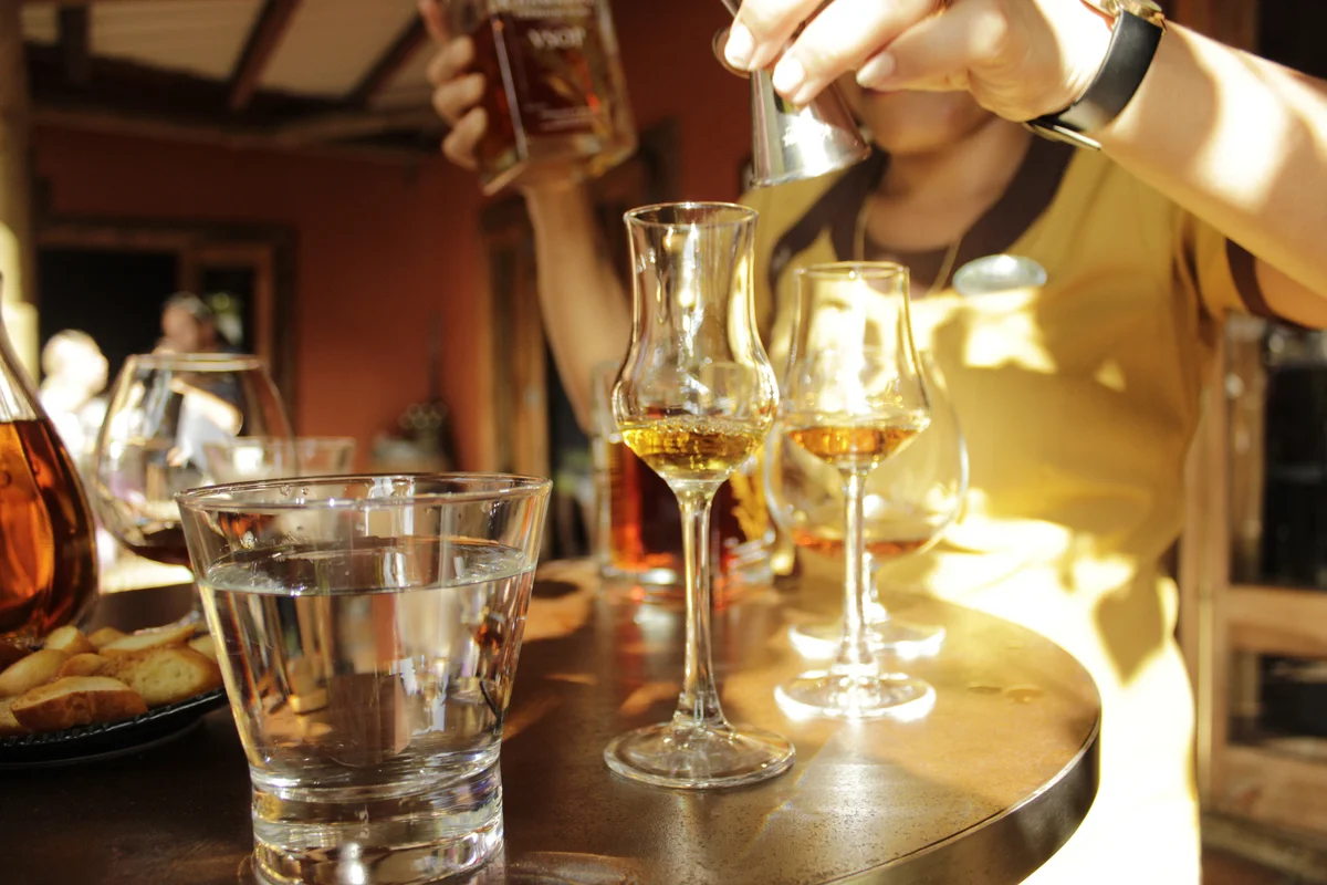 Bartender mixing drinks in small glasses