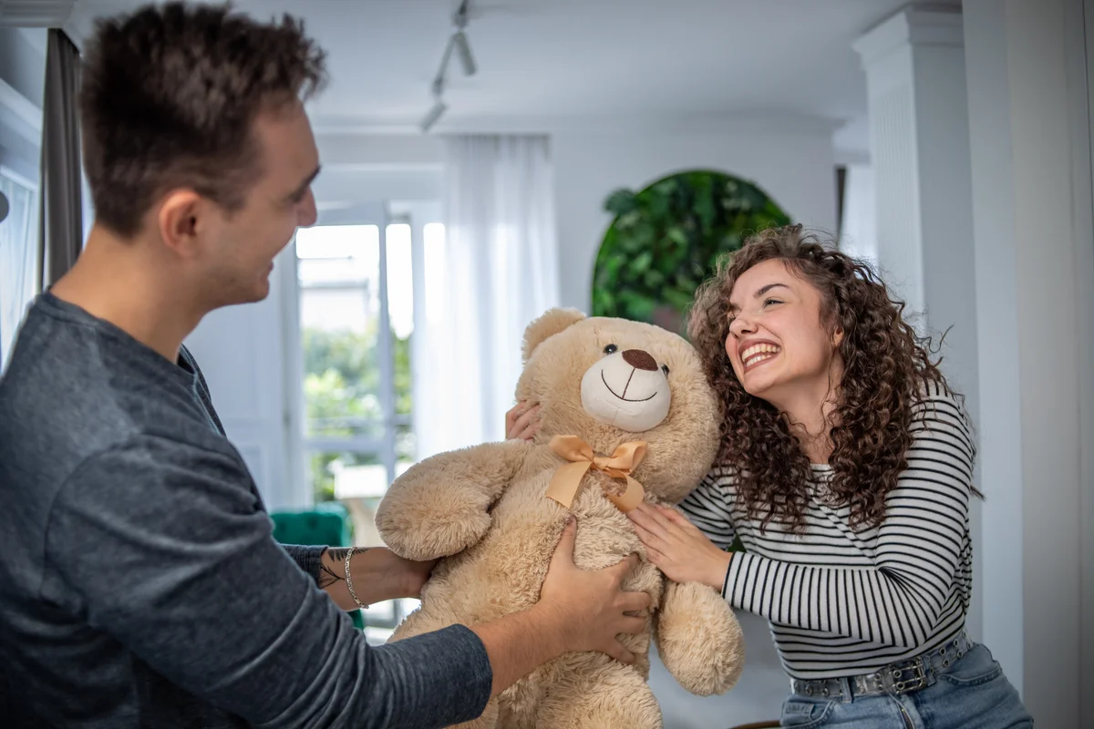 Guy giving girl teddy bear