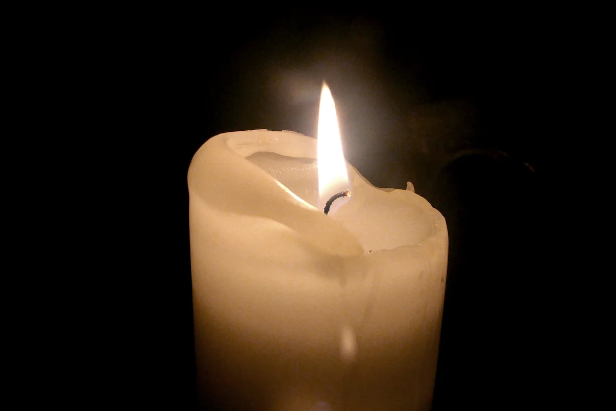 Illuminated Candle In Darkroom
