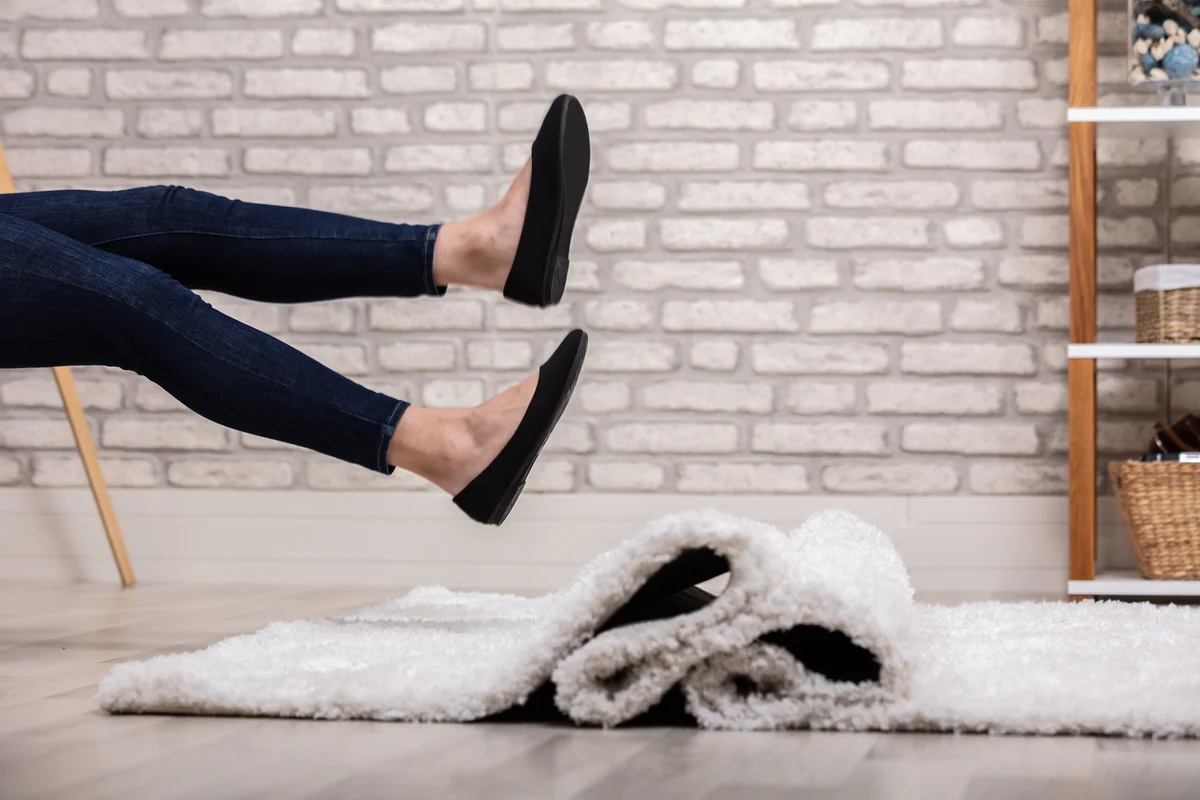 Woman sitting and kicking her heels into the air wearing black flats