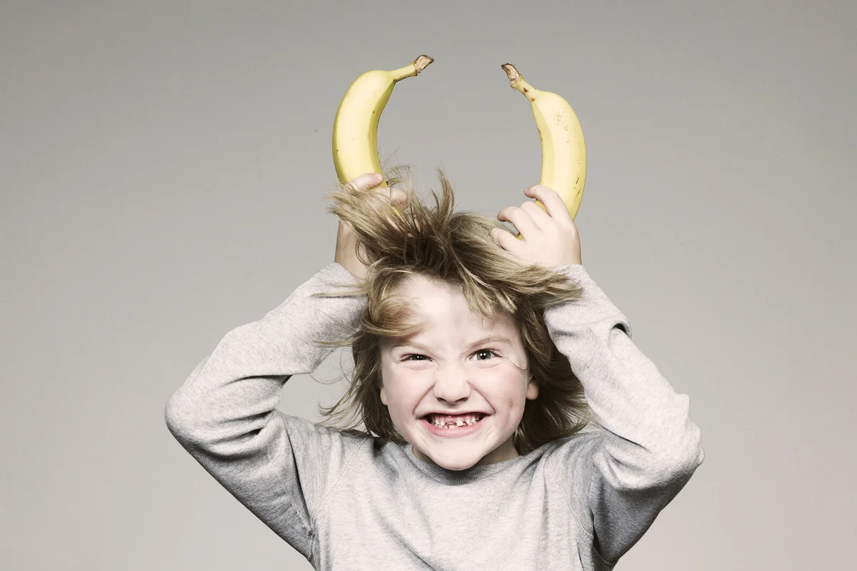Boy holding two banana on head
