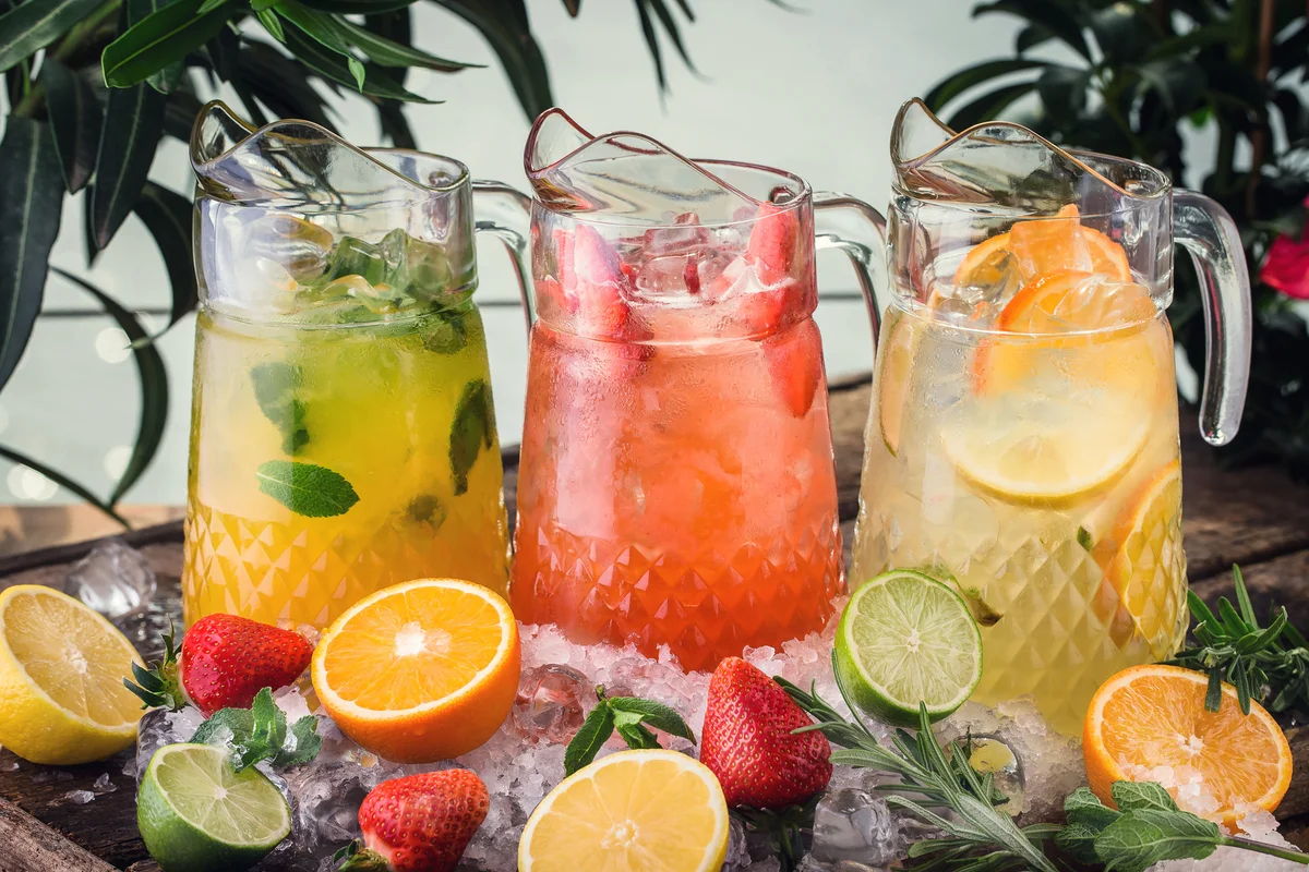 Three pitchers of various fruity drinks