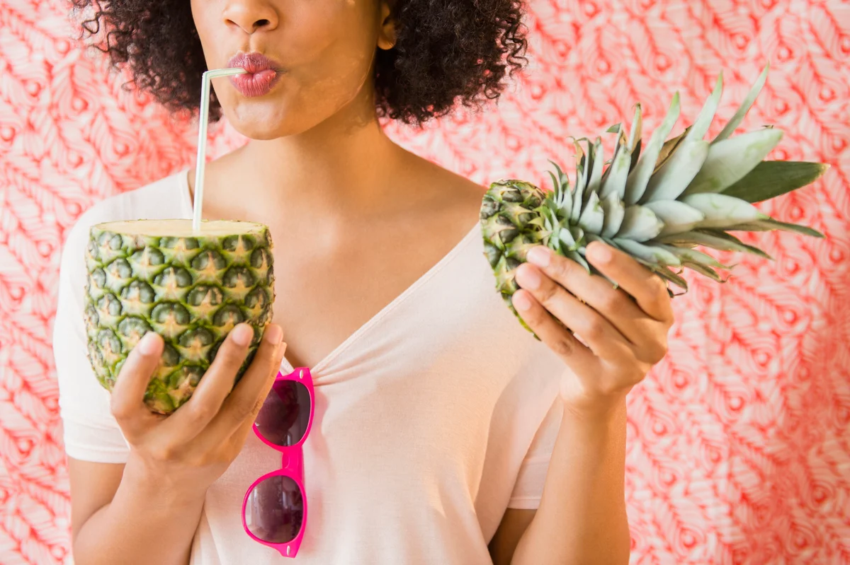 Woman drinking from Pineapple
