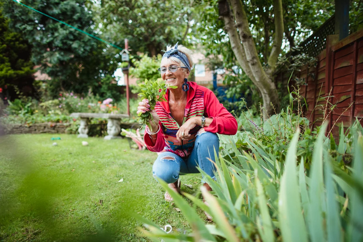 Woman enjoying plants in shady garden