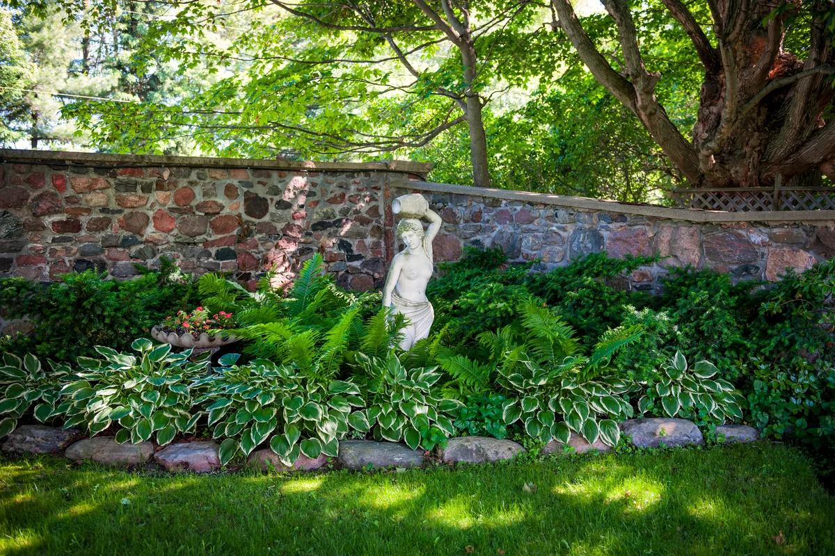 Statue of woman in a shady garden