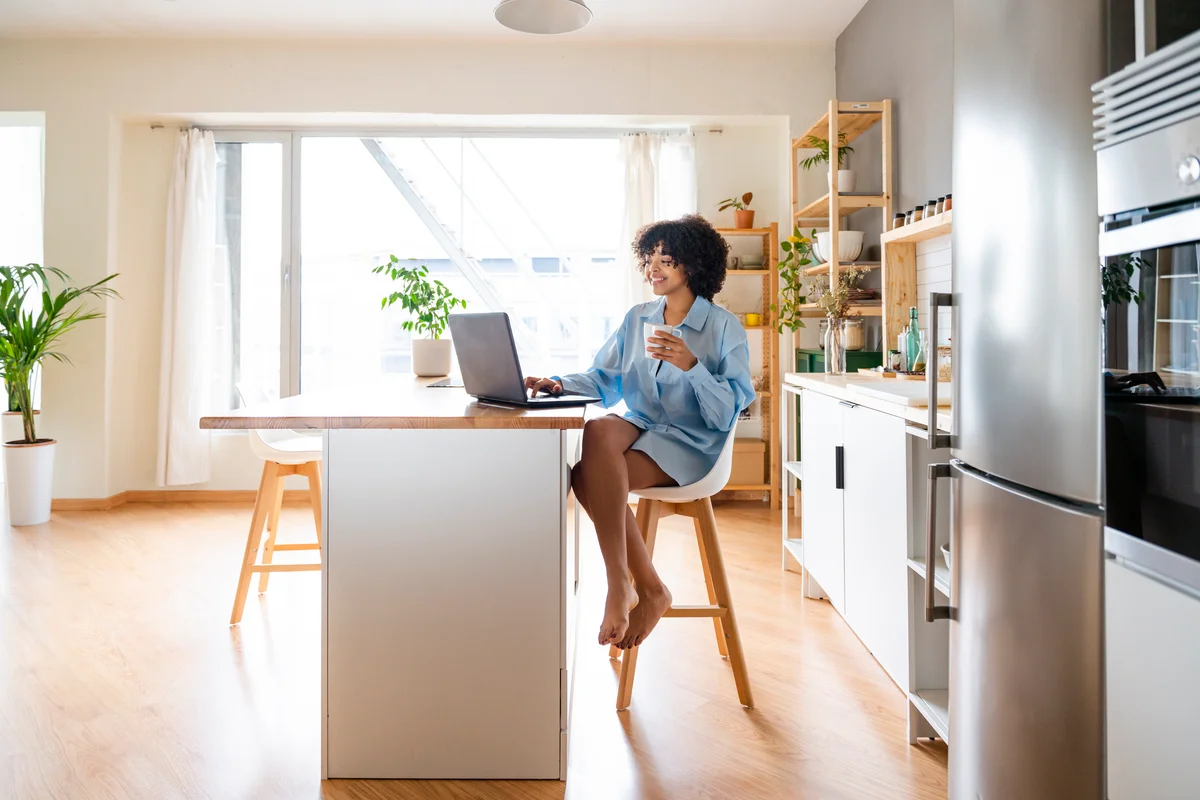 Woman working on laptop at kitchen island