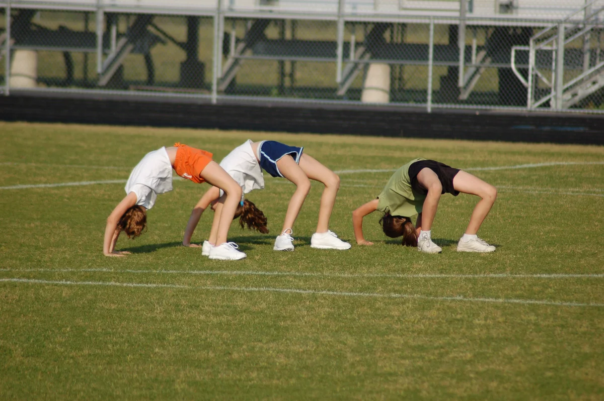 Girls crab-walking on football field