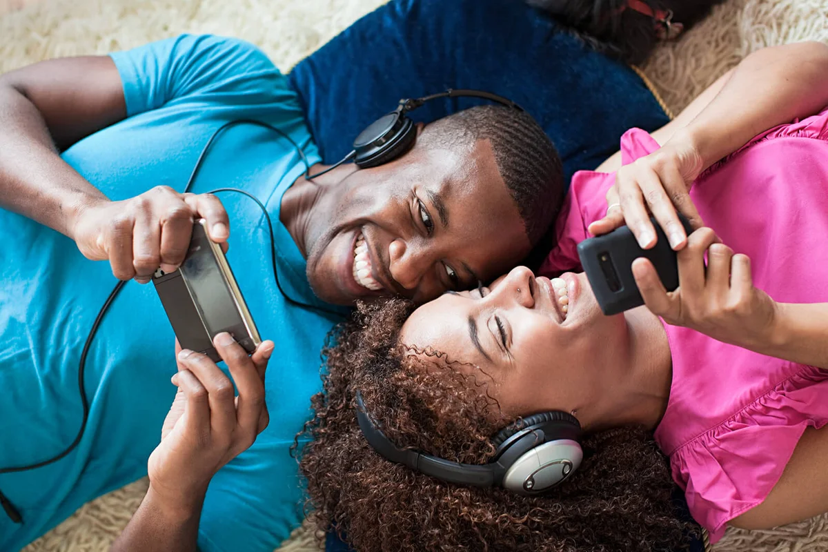 Man and woman playing on handheld device and smartphone