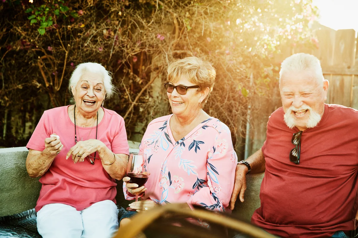 Senior friends sitting outside chatting and sharing memories