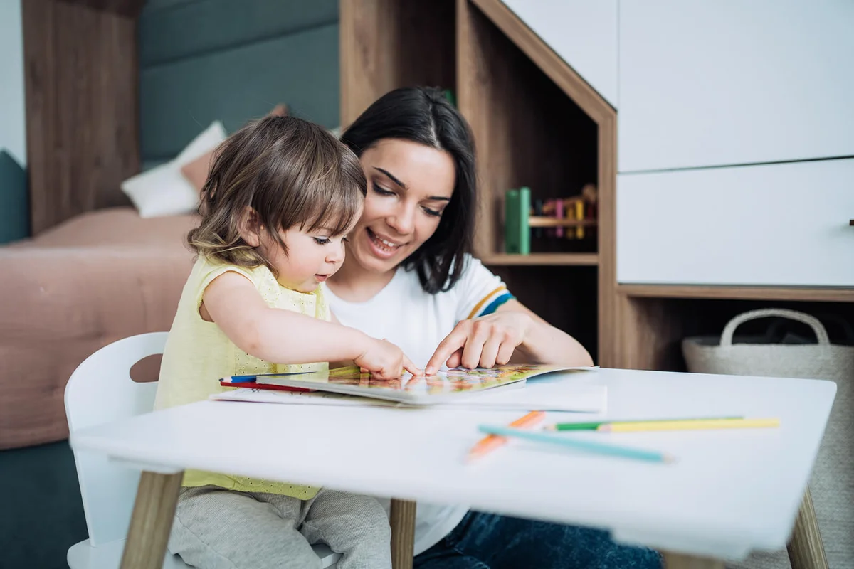 Babysitter and little girl drawing together