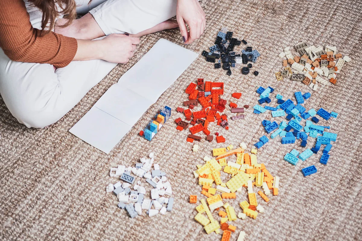 Female hands playing with toys on the carpet