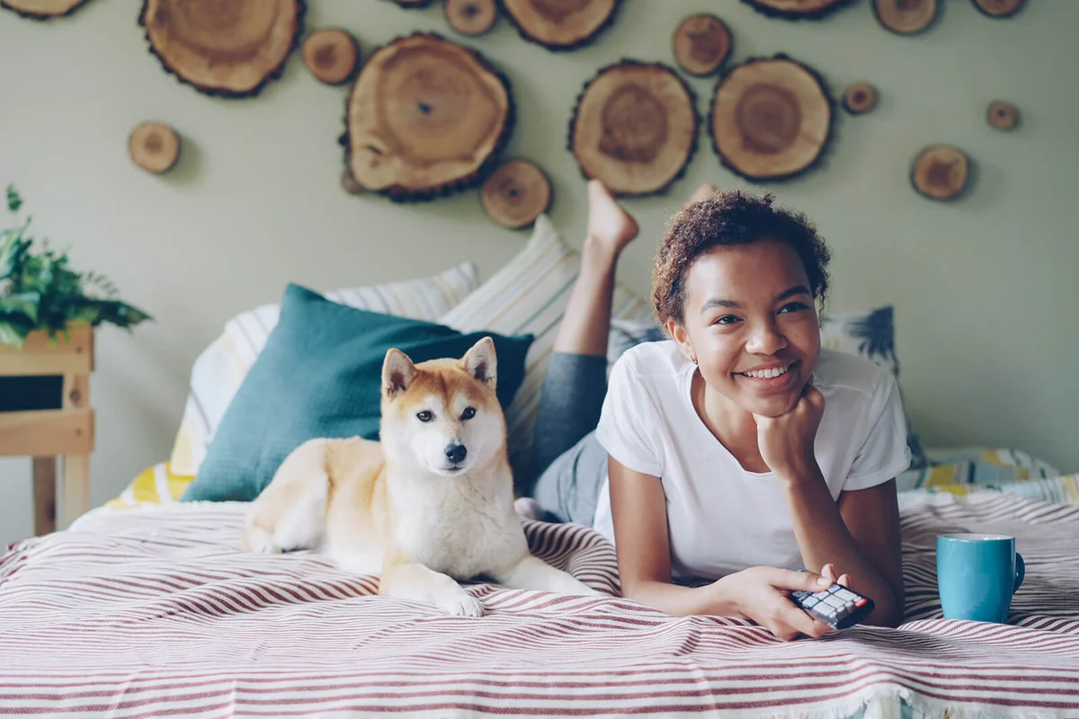 Cheerful girl watching movies with her dog