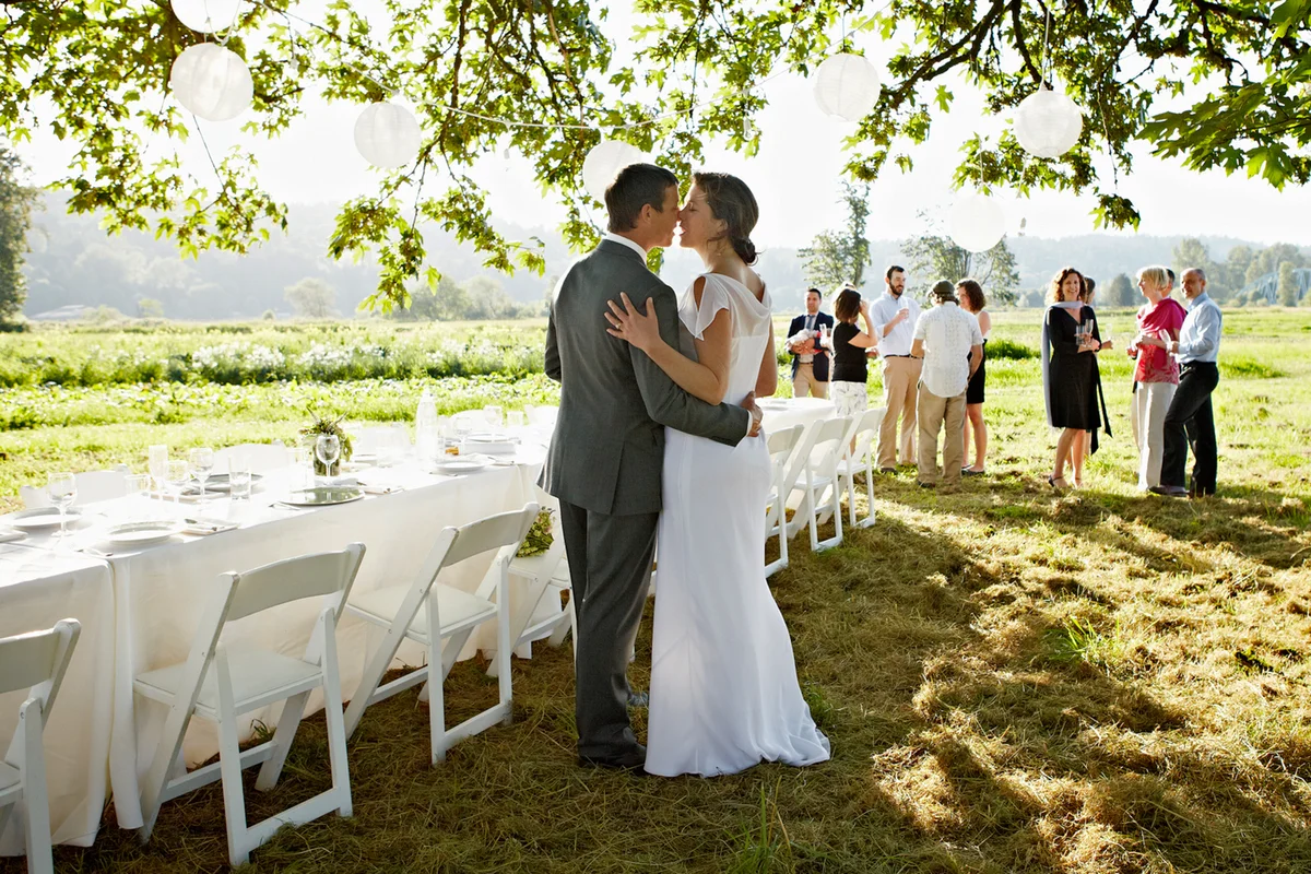 Bride and groom embracing about to kiss near table