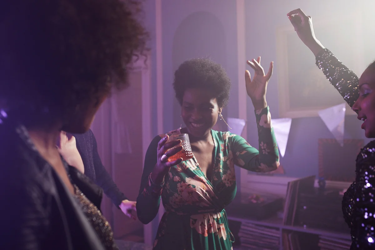 Young women dancing and cheering at home party