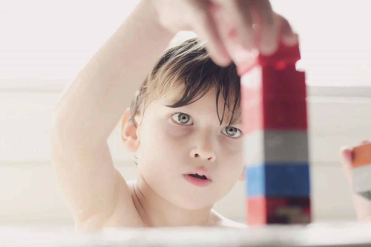 Little boy playing with blocks in the tub