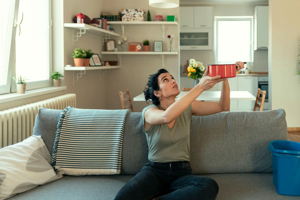 Woman Looks at the Ceiling While Collecting Water