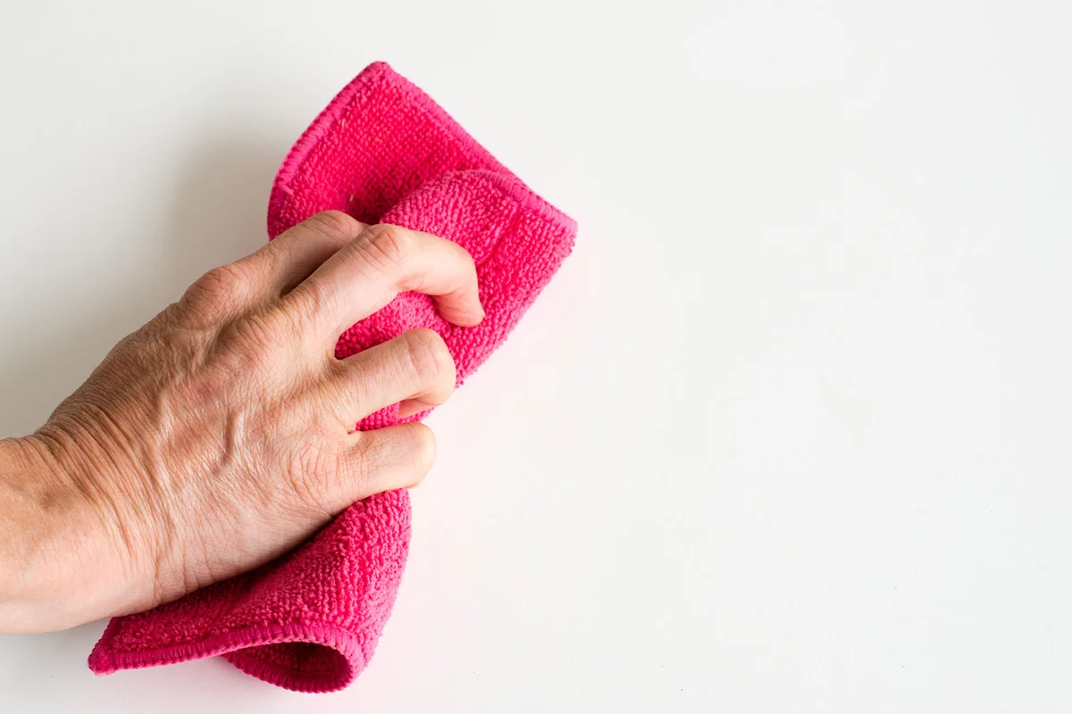 Hand cleaning wall with pink cloth