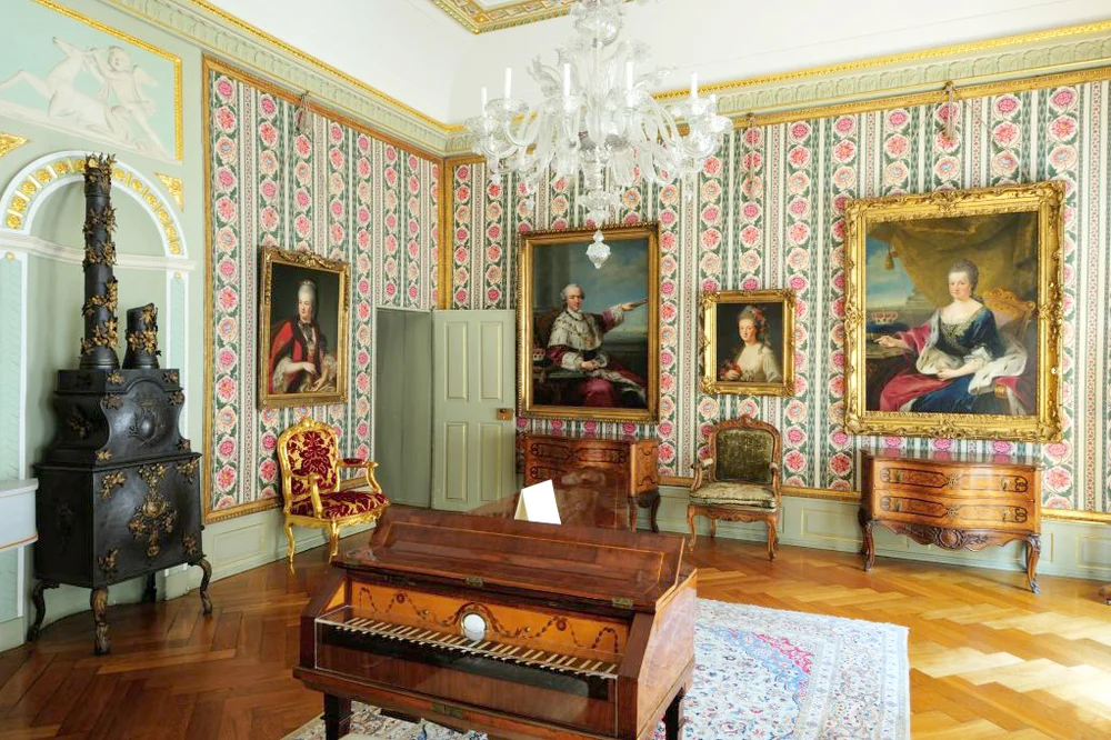 Victorian living room with portraits on the walls and a stove