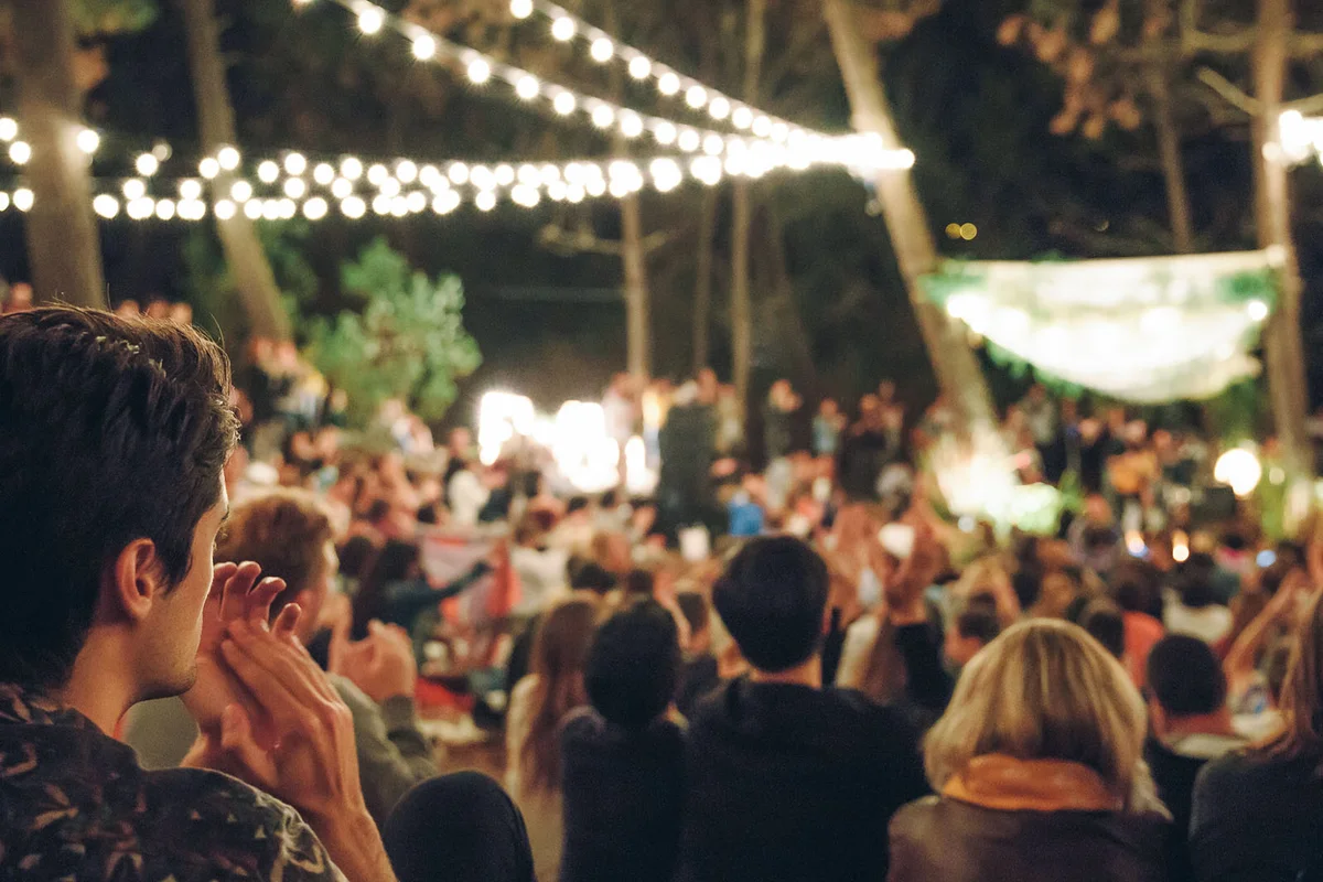 Young man clapping in night music festival