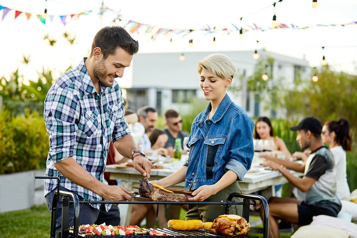 Smiling young man serving meat to woman